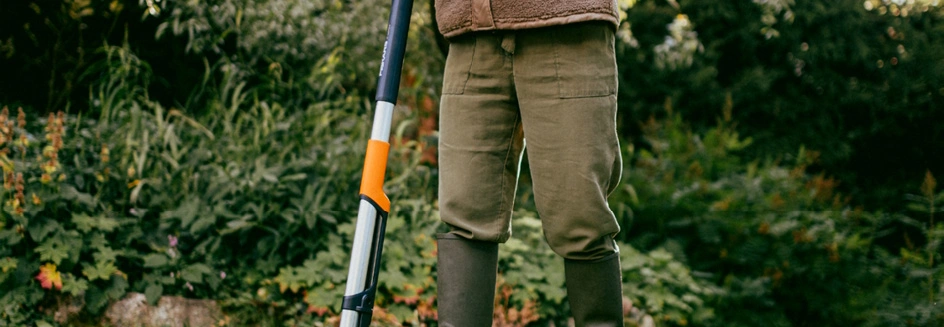 Eine Person nutzt einen Unkrautstecher von Fiskars